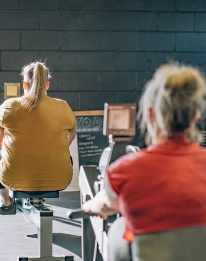 Fight for it CrossFit group training session with athletes using rowing machines